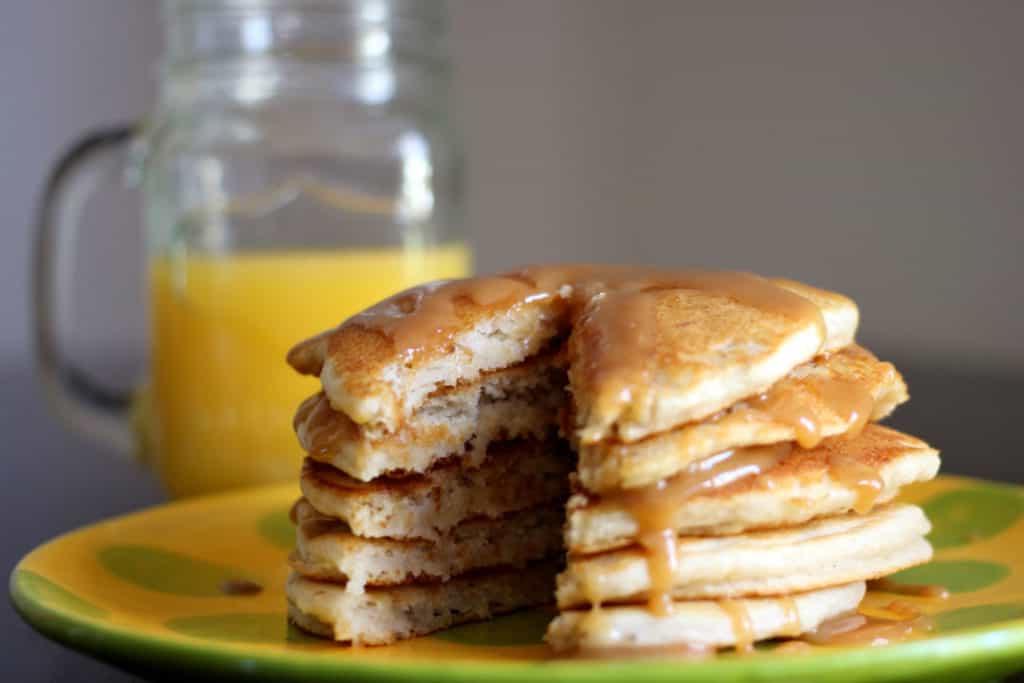Stack of banana pancakes with a slice taken out.