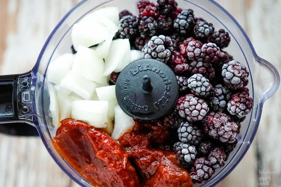 Blackberries, onion, and chipotle peppers are added to the food processor.