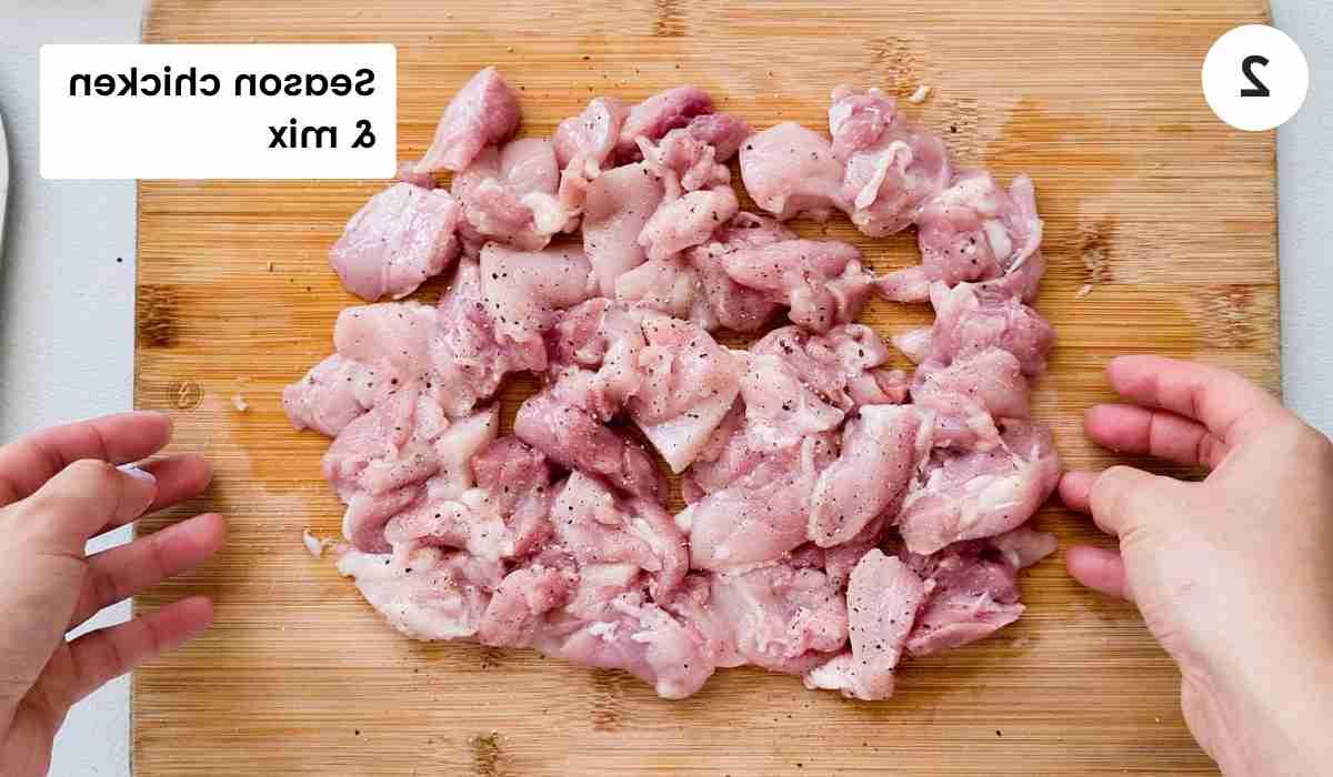 seasoned cut up chicken thighs on a cutting board with caption