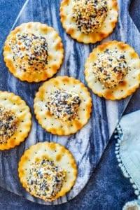 Cheese ball bites on a blue marble cutting board on a blue counter.