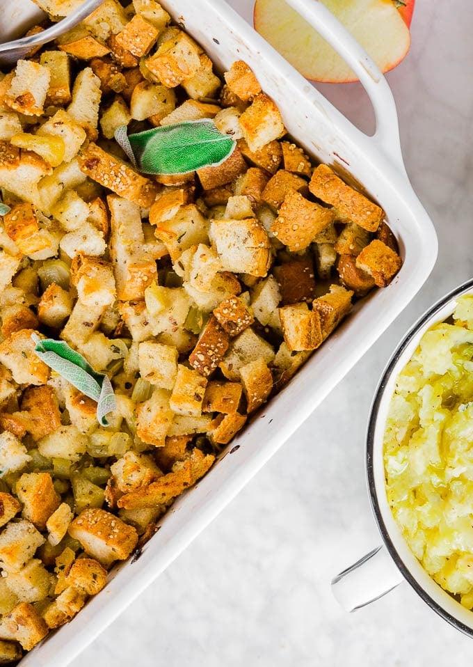 A baking dish with easy gluten-free stuffing topped with fresh sage.