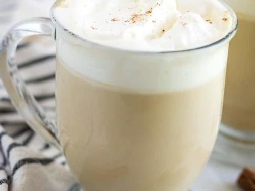 The coffee drink has been garnished with whipped cream and ground cinnamon.