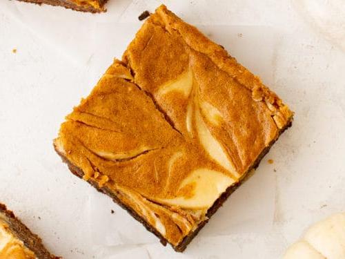 Top down view of cream cheese swirled in a pumpkin brownie.