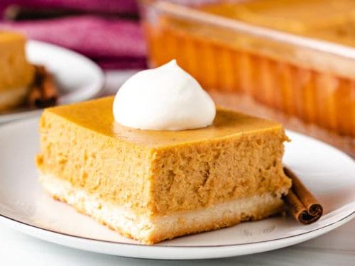 Square piece of pumpkin cheesecake on a plate.