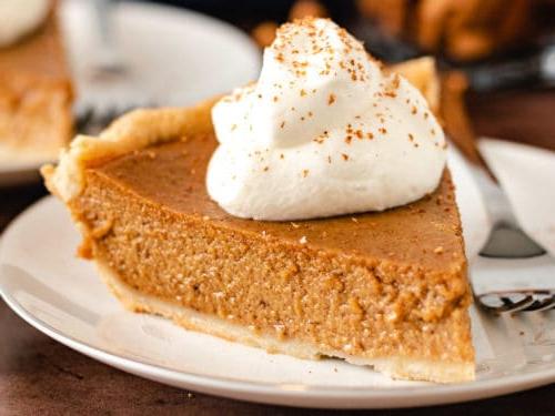 Pie with whipped cream and sprinkled cinnamon.