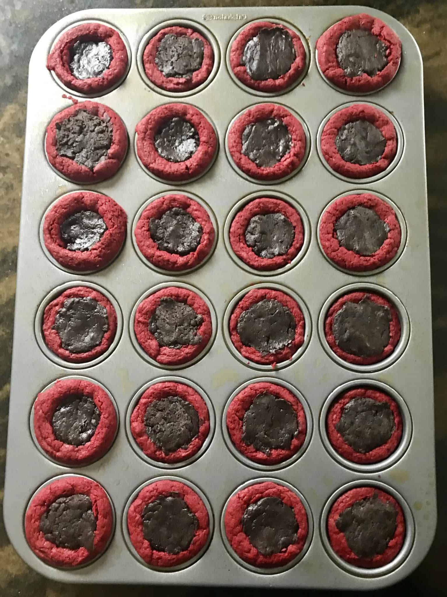 red velvet cake mix balls in mini muffin pan filled with Oreo truffle mix overhead shot