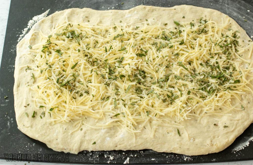 cheese and herb sprinkled on dough