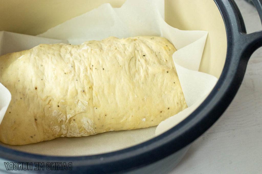 dough on parchment in cast iron pot